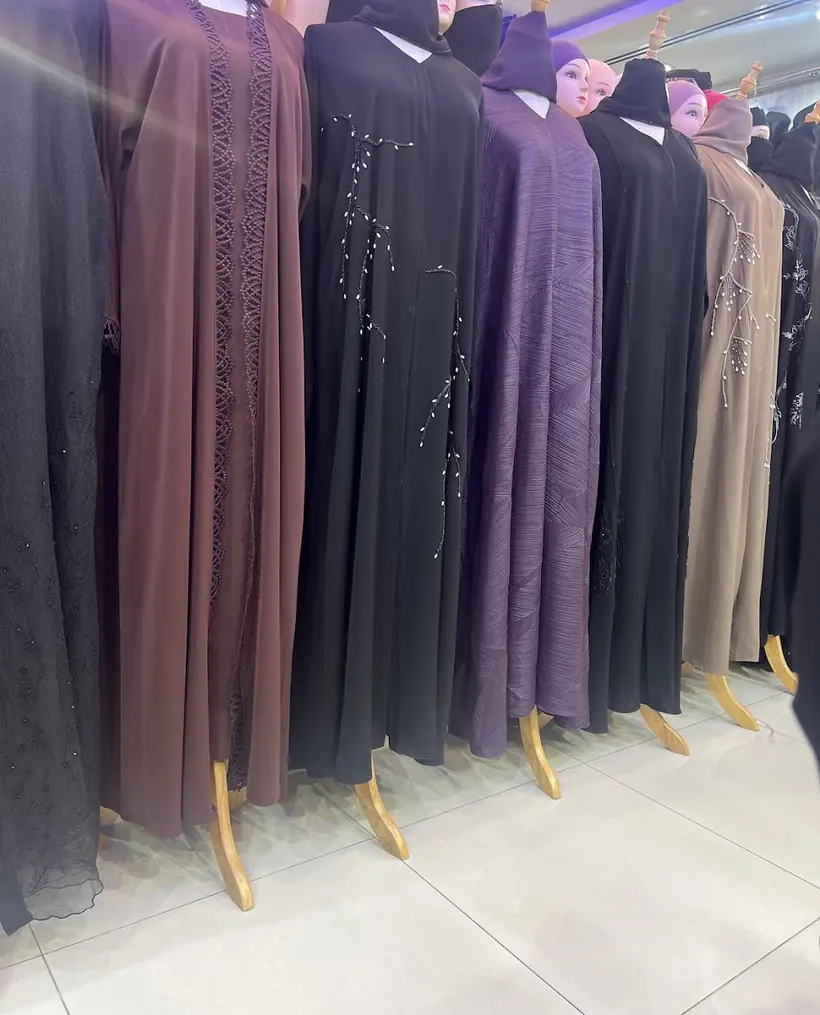 Abayas in black, brown, beige and grey on the rail inside Red Chic